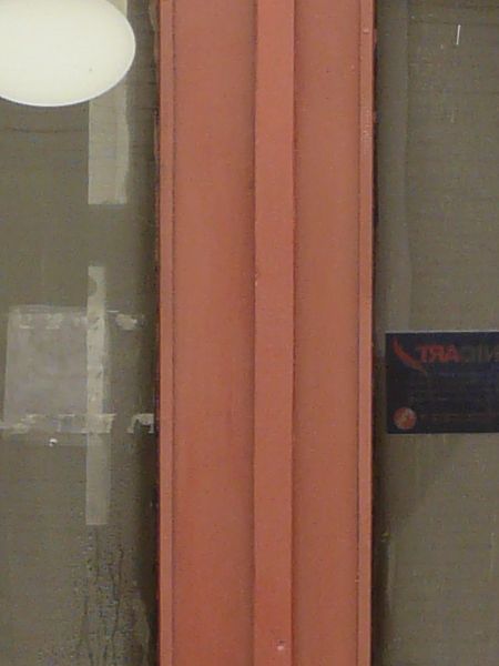 Tall wooden doors in dark red tone with glass windows.